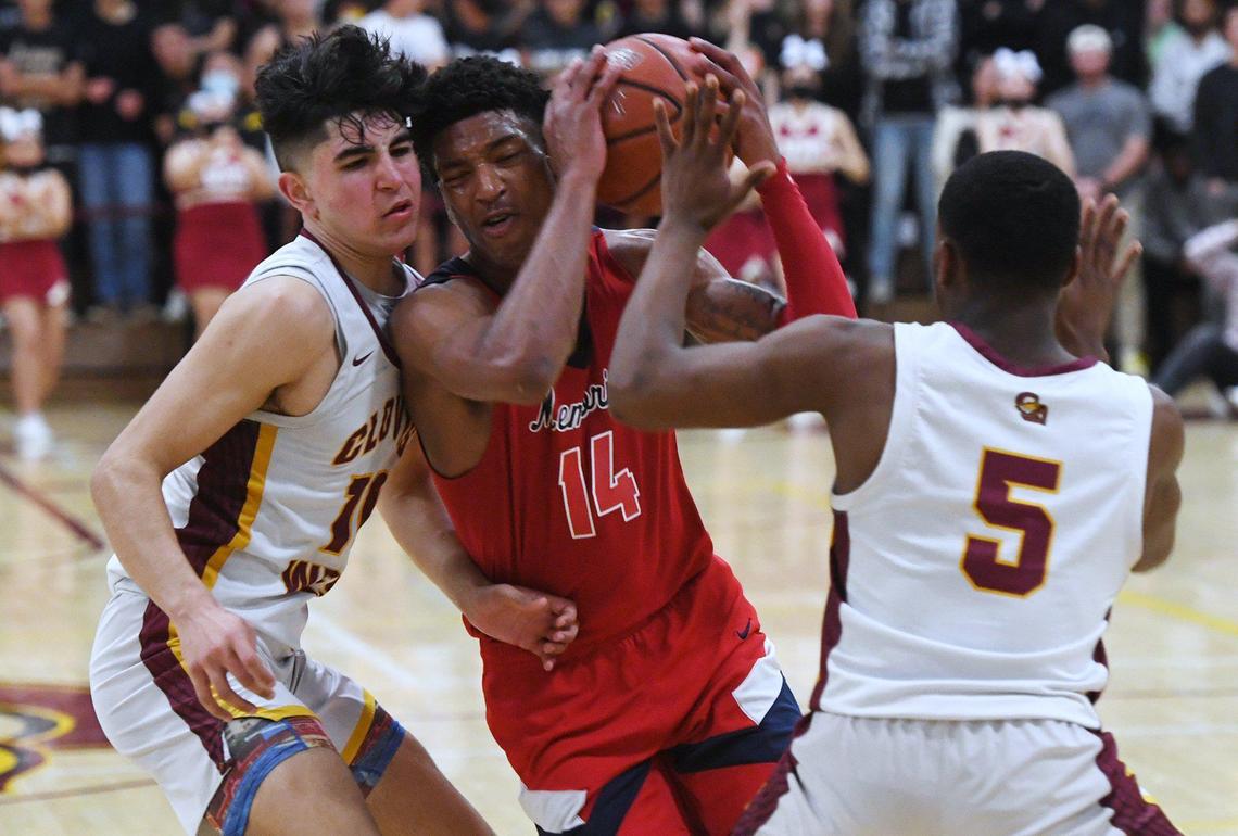 Clovis West’s Zach Chauhan, left, and Markel Sanders, right, block San Joaquin Memorial’s Joseph Hunter, center, in Open Division action Saturday, Feb. 19, 2022 in Fresno. Clovis West defeated San Joaquin Memorial 83-69.