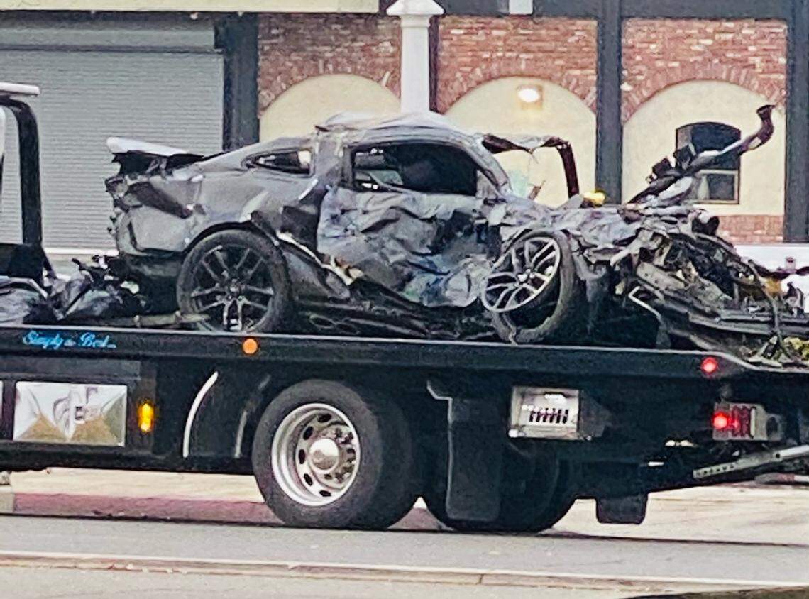 The Ford Mustang involved in a crash late Saturday night in northwest Fresno sits on a flatbed hauler at the scene Sunday morning.