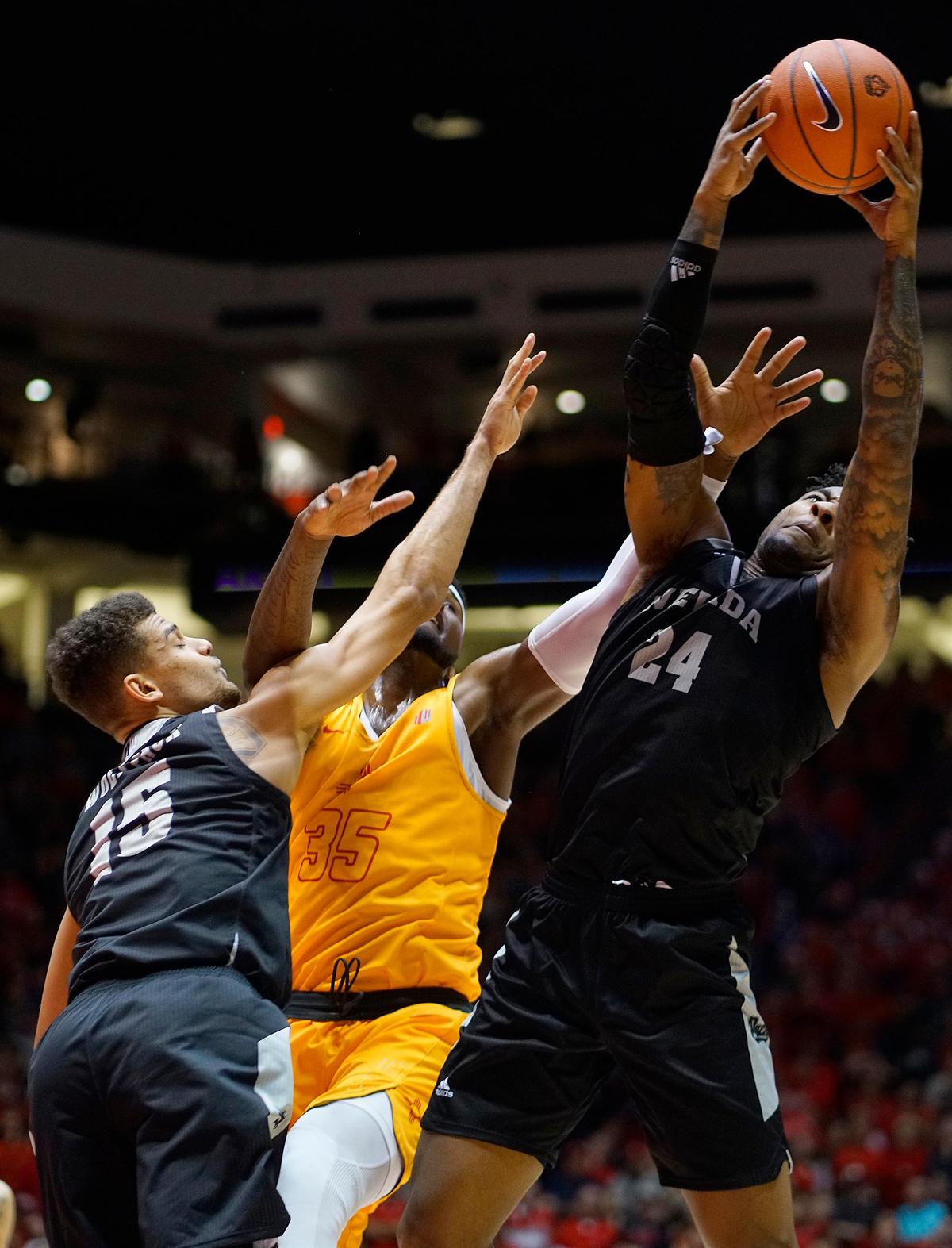 New Mexico’s Carlton Bragg (35) battles Nevada’s Trey Porter (15) and Jordan Caroline (24) for a rebound during the Lobos’ 85-58 victory over the No. 6 Wolf Pack, Saturday, Jan. 5, 2019, in Albuquerque, N.M.