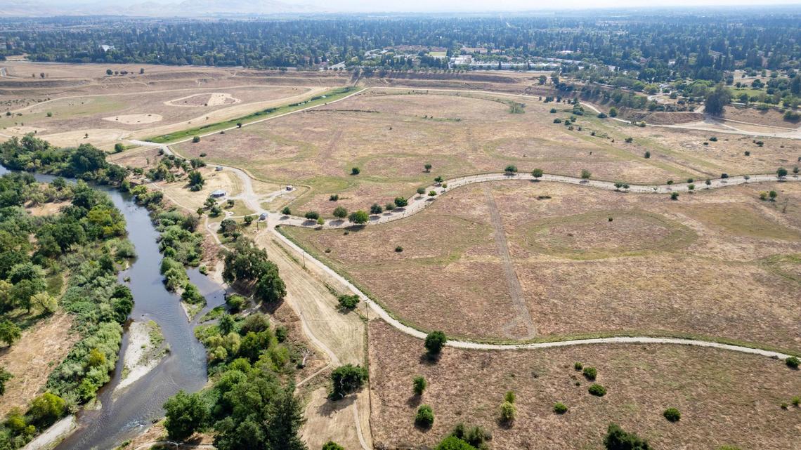 The San Joaquin River, left, curves past the Jensen River Ranch area that is part of the San Joaquin River Conservancy with its trail access points just to the north of Fresno’s Woodward Park in this drone image taken on Wednesday, April 20, 2025.
