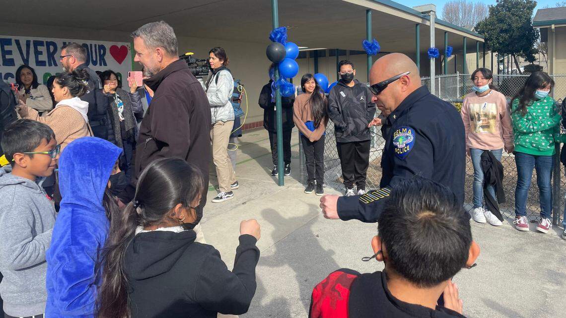 A Selma police officer prepares to fist bump Eric White Elementary students during a Tuesday, Feb. 14, 2023 event to thank the department for their commitment to the Selma Unified school community.
