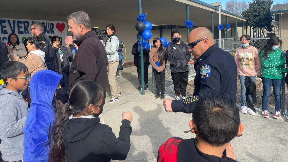 A Selma police officer prepares to fist bump Eric White Elementary students during a Tuesday, Feb. 14, 2023 event to thank the department for their commitment to the Selma Unified school community.