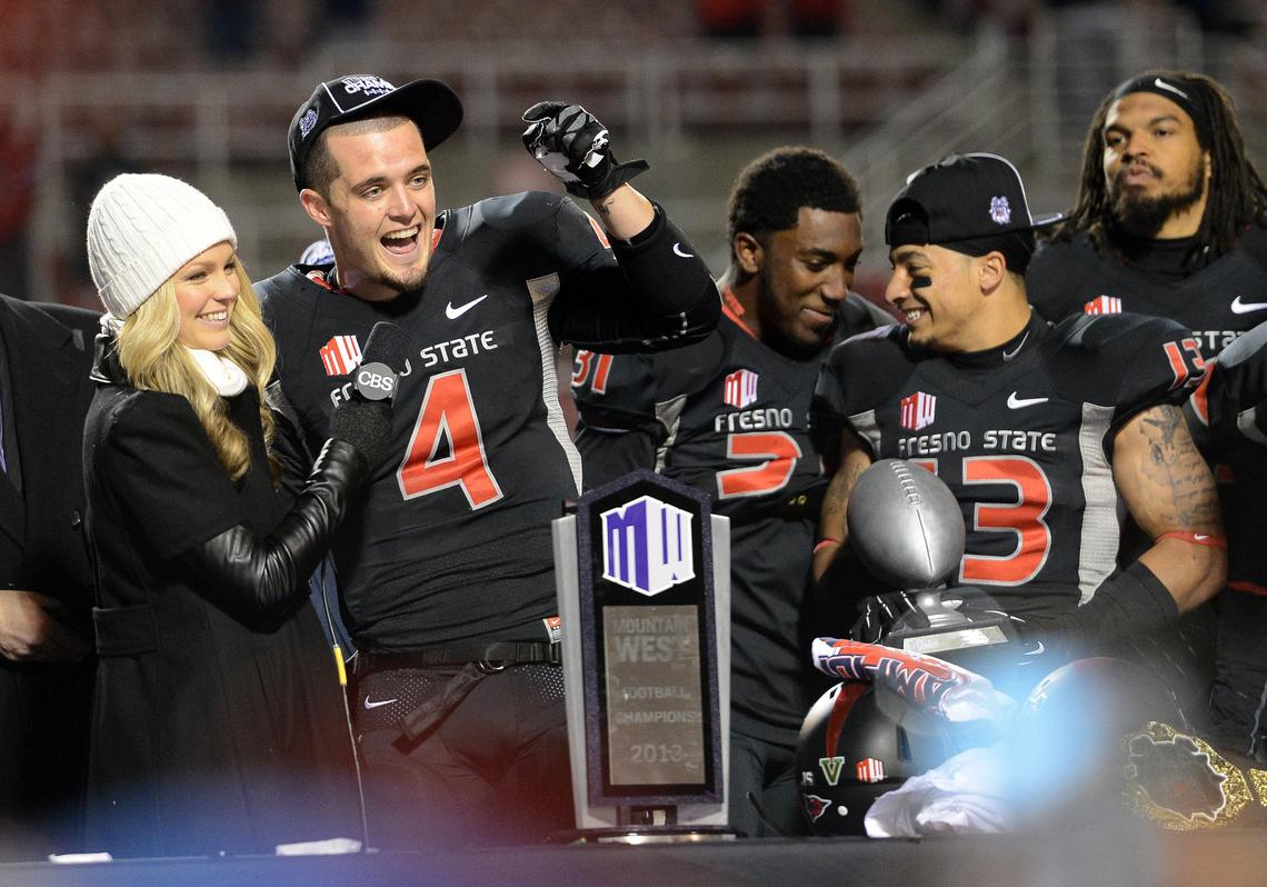 Fresno State quarterback Derek Carr, second from left, is interviewed at the podium after the Bulldogs won the Mountain West Conference championship game against Utah State at Bulldog Stadium Saturday, December 7, 2013.