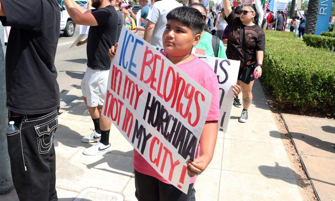 A boy carries a sign during the No Kings Rally held June 14, 2025 at Riverpark Shopping Center.