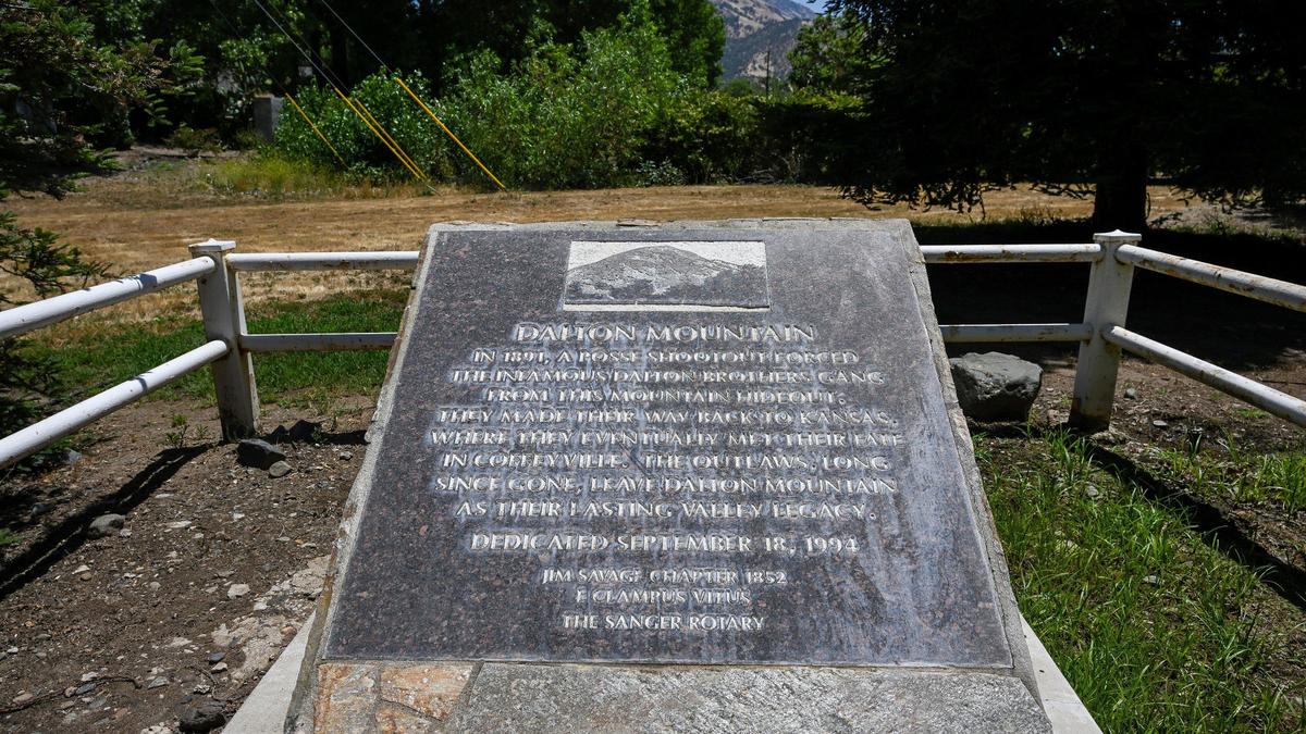 An historical marker stands on land at the Wonder Valley Ranch in eastern Fresno County on Thursday, May 30, 2024. The marker points toward Dalton Mountain where the Dalton brothers outlaw gang had their hideout prior to being killed in a failed robbery attempt in Kansas in 1892.