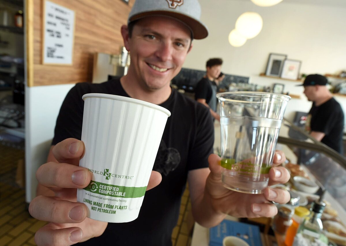 The Revue owner Jeff Bennett shows compostable cups that are used now in the coffee shop. The Revue has also switched to compostable lids and straws.