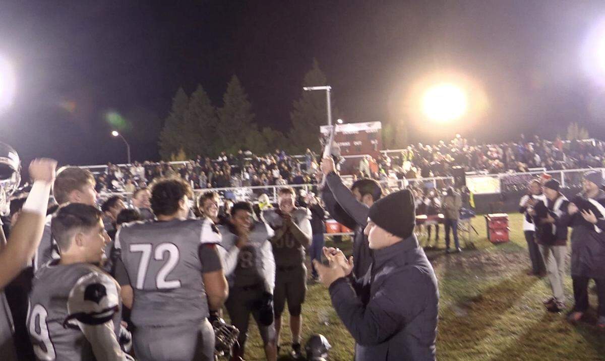 Fresno Christian coach Mick Fuller presents the Central Section eight-man championship to his team after a 30-27 victory over Sierra on Friday, Nov. 18, 2022.