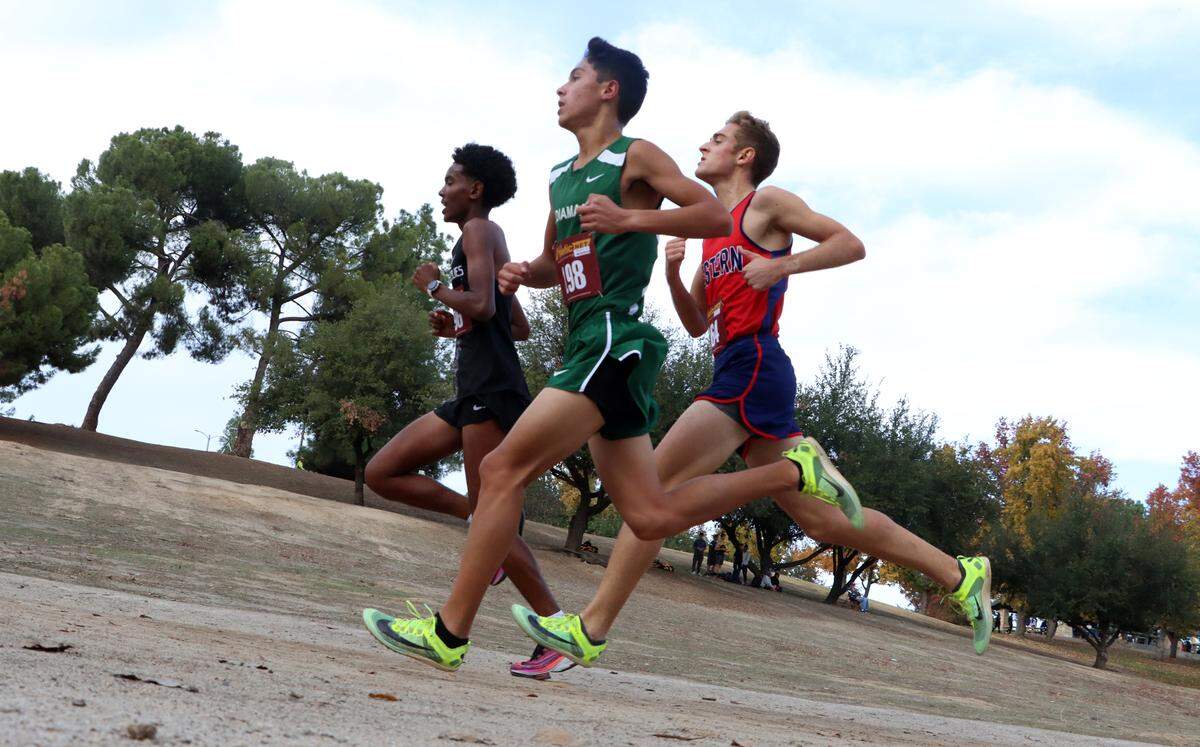 Alazar Teffra of Central has a slight lead over runner-up Devin Ibarra of El Diamante and Carter Mendes of Tulare Western in the CIF Central Section Division II Cross Country Championships at Woodward Park on Nov. 17, 2022. Teffra won in 15:58.22, while Ibarra was second in 16:04.2, and Mendes third in 16:09.54. Tulare Western won the team title.