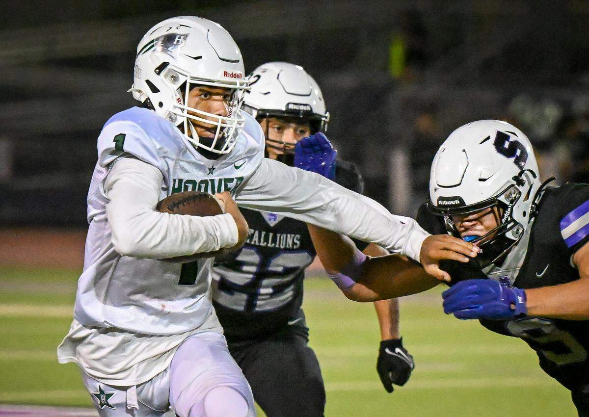 Hoover quarterback Cam Mobley weaves his way past the Madera South defense on a keeper during their game at Madera South Stadium on Friday, Sept. 19, 2025.