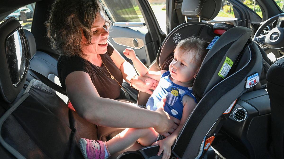 Amanda Tripp of Fresno puts her daughter Ellie, 2, into her car seat after picking her up from her child care provider on Thursday, June 16, 2022. After a difficult search, Tripp was able to find the licensed child care provider when her original provider closed her business last year.