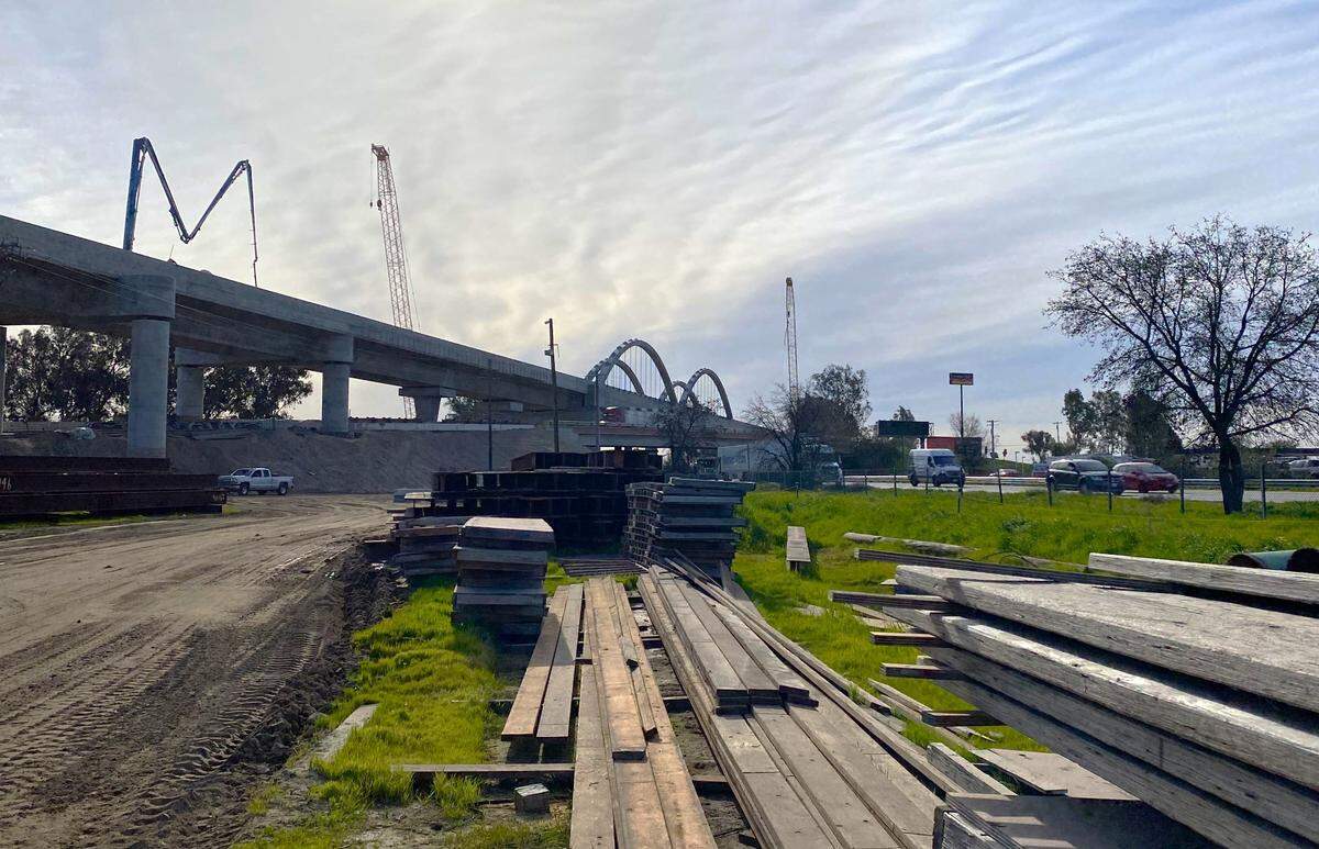 Traffic on Highway 99 at the south end of Fresno flows beneath a high-speed rail viaduct under construction on Feb. 14, 2023.