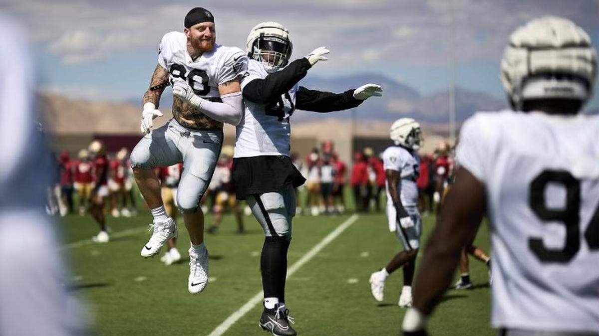 Las Vegas Raiders defensive end Maxx Crosby and linebacker Robert Spillane celebrate during a joint practice with the San Francisco 49ers on Friday, Aug. 11, 2023.