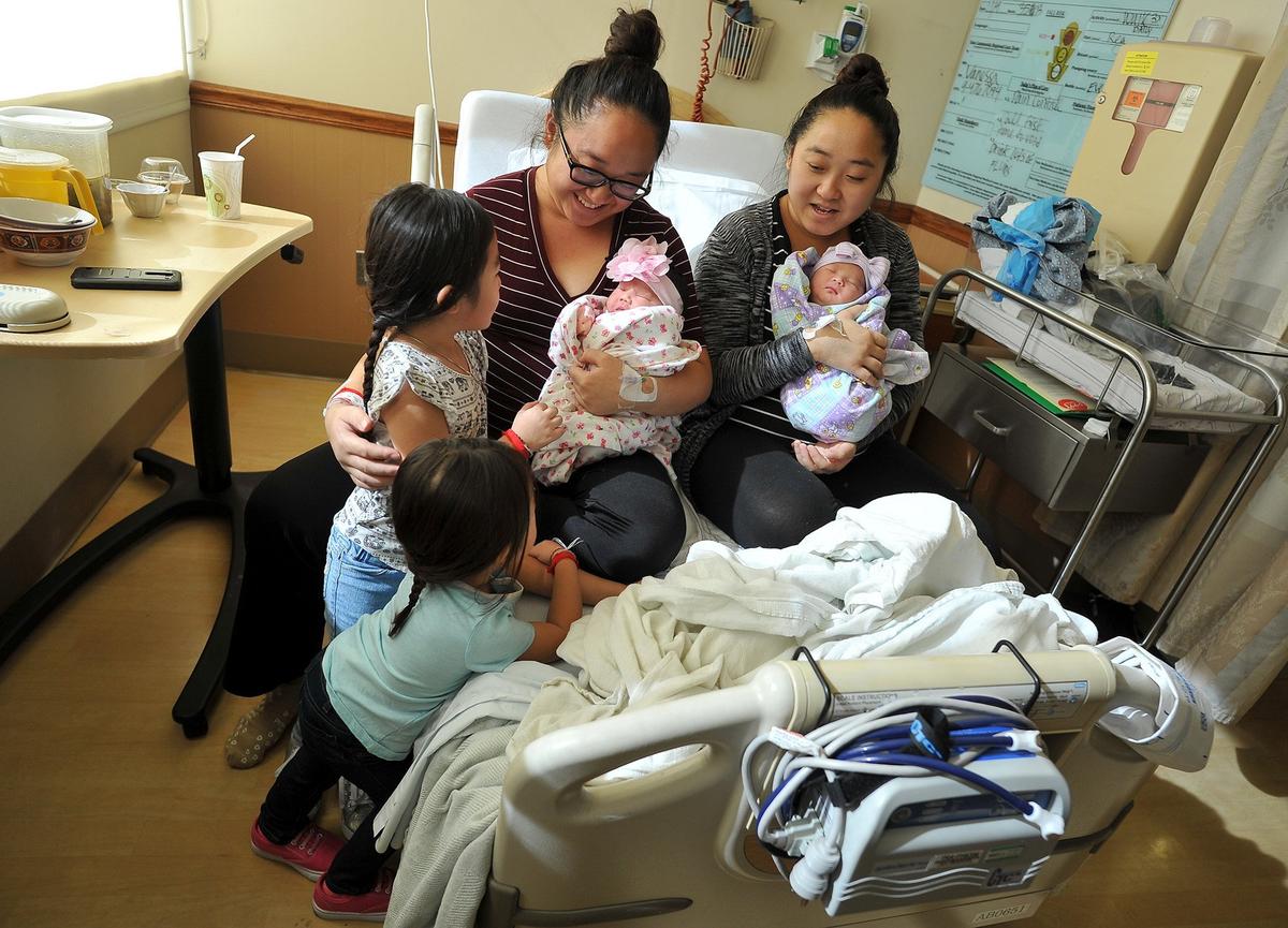 Karina Thao, 3, bottom left, and older sister Susana Thao, 5, meet their new sister, Candra Thao, for the first time, held by their mother, BaoNhia Yang, as her identical twin, Baokou Yang, holds her daugher, Nadalie Xiong, on Monday morning, Nov. 5, 2018, at Community Regional Medical Center. The twin sisters gave birth to their daughters on Sunday, just about two hours apart.