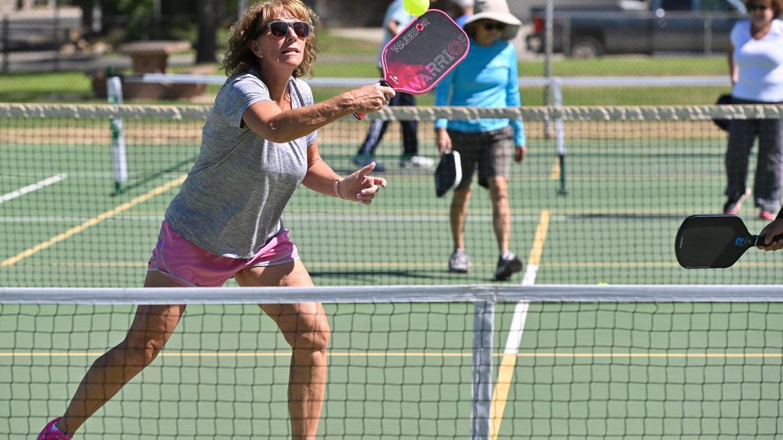 Laurie Werner returns the ball in a doubles pickleball game played on a tennis court at Rotary East Park Wednesday morning, June 21, 2023 in Fresno. Although surrounding towns have dedicated pickleball courts, Fresno and Clovis area fans of the game must share the use of tennis courts with added pickleball lines.