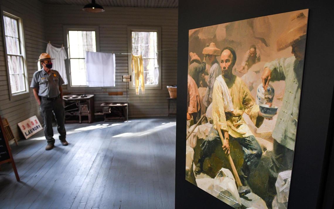 A print of a painting by artist Mian Situ is displayed among other artifacts illustrating the nature of work once done in the Chinese Laundry Building near the Yosemite History Center in Yosemite’s Wawona on Tuesday, Sept. 28, 2021. The building is being dedicated in honor of its original purpose as a laundry building for the Wawona Hotel and the Chinese immigrants who ran it.