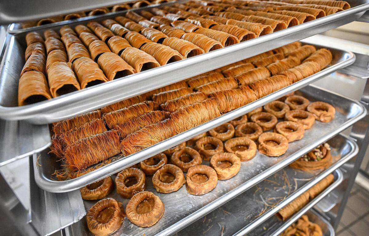 Trays of Middle Eastern pastries are prepped for the display cabinet at Rumi Baklava, a new bakery on West Shaw Avenue at Marks in Fresno.