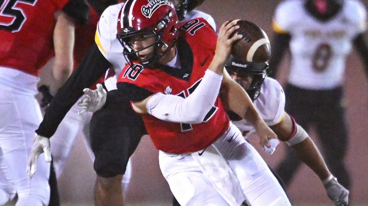 Hanford’s Daniel Gomez is pressured by Tulare Union’s Dominic Wilson and Nathan Cordova, background, in first half action Friday, Oct. 11, 2024 in Hanford.