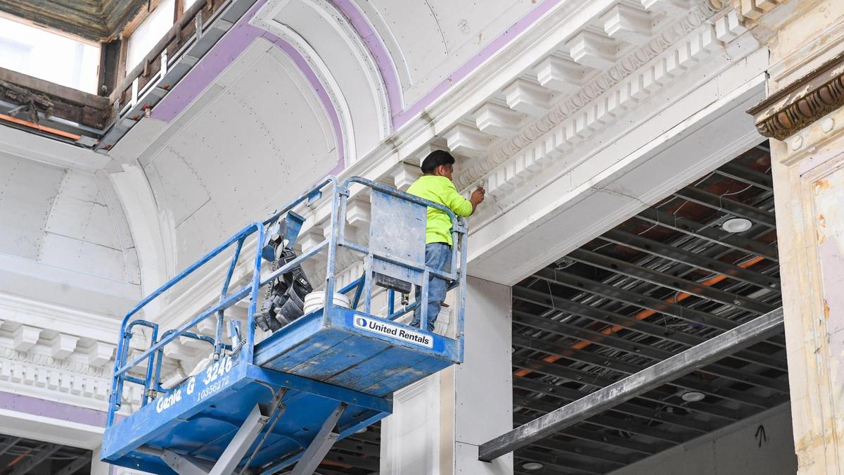 The crown molding is detailed by a worker in the atrium lobby of the historic Hotel Fresno, currently being renovated as an affordable apartment housing project, on Thursday, Oct. 7, 2021.