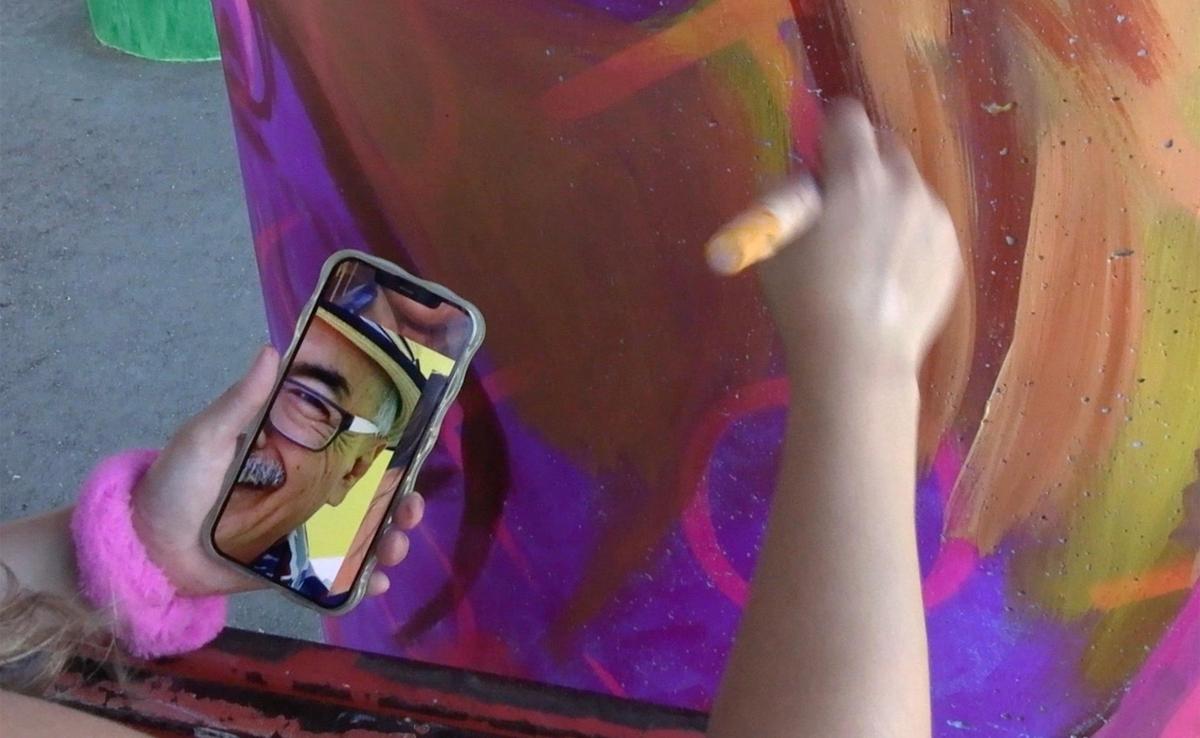Muralist Andrea Cano Torres paints a support pillar working from a photo of US Poet Laureate and writer Juan Felipe Herrera underneath Highway 180 at San Pablo Park Thursday, July 17, 2025 in Fresno. The murals by several artists are a collabortion between the Fresno Arts Council and Caltrans, said muralist ANdrea Cano Torres.