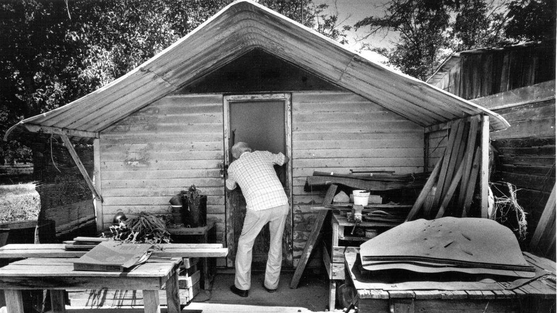 In this photo taken in 2000, Delbert Searcy of Visalia peers inside a farm labor camp cabin like the one he lived in at the Linnell Labor camp.