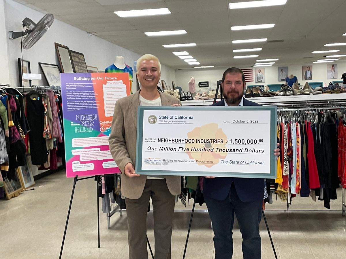 California state Assebmlymember Joaquin Arambula (right) presents a check for $1.5 million to Neighborhood Industries CEO Anthony Armour.