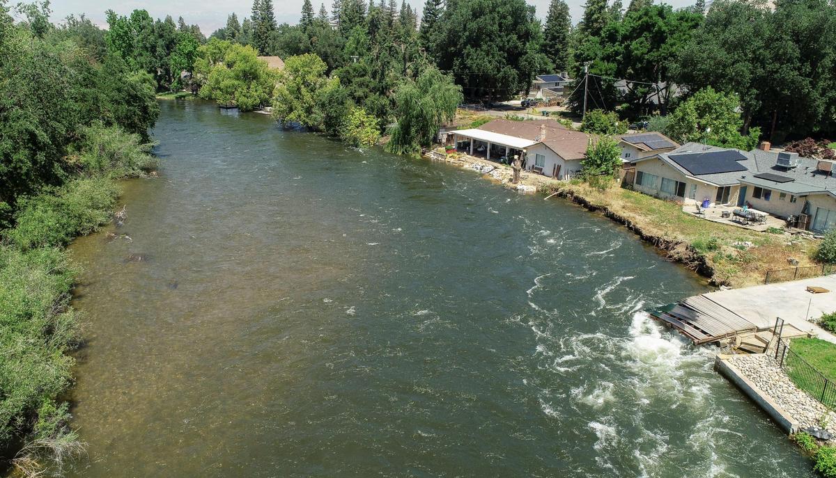 The Kings River flows at a high rate causing some bank erosion near a housing area north of Highway 180 and Piedra Road in eastern Fresno County on Wednesday, May 17, 2023.