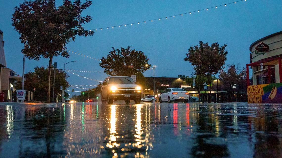 Water begins to puddle up on Olive Avenue in Fresno’s Tower District on a rainy evening, Tuesday, Nov. 1, 2022.