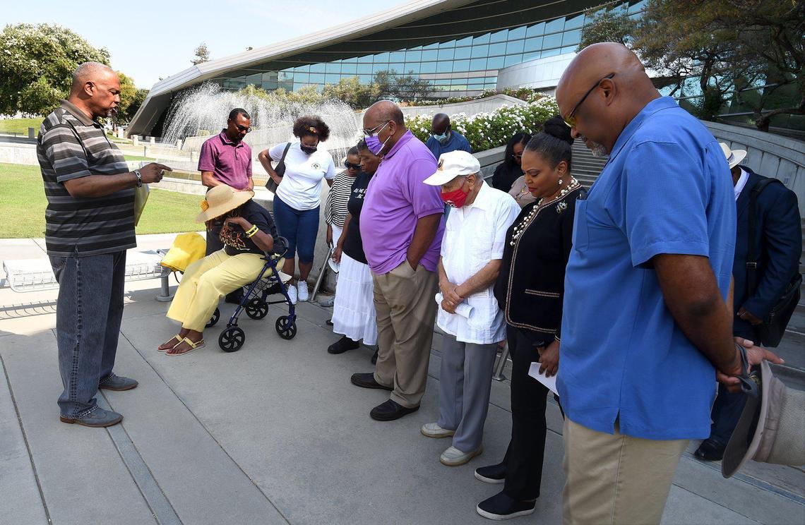 At the steps of Fresno City Hall, Pastor B.T. Lewis of Rising Star Missionary Baptist Church, left, leads members of the Fresno Black Leadership Collective in prayer before a press conference, Tuesday July 13, 2021, calling for the city to initiate a ant-racist task force, and to protest the firing of longtime&nbsp;Fresno City&nbsp;Clerk&nbsp;Yvonne&nbsp;Spence.&nbsp;