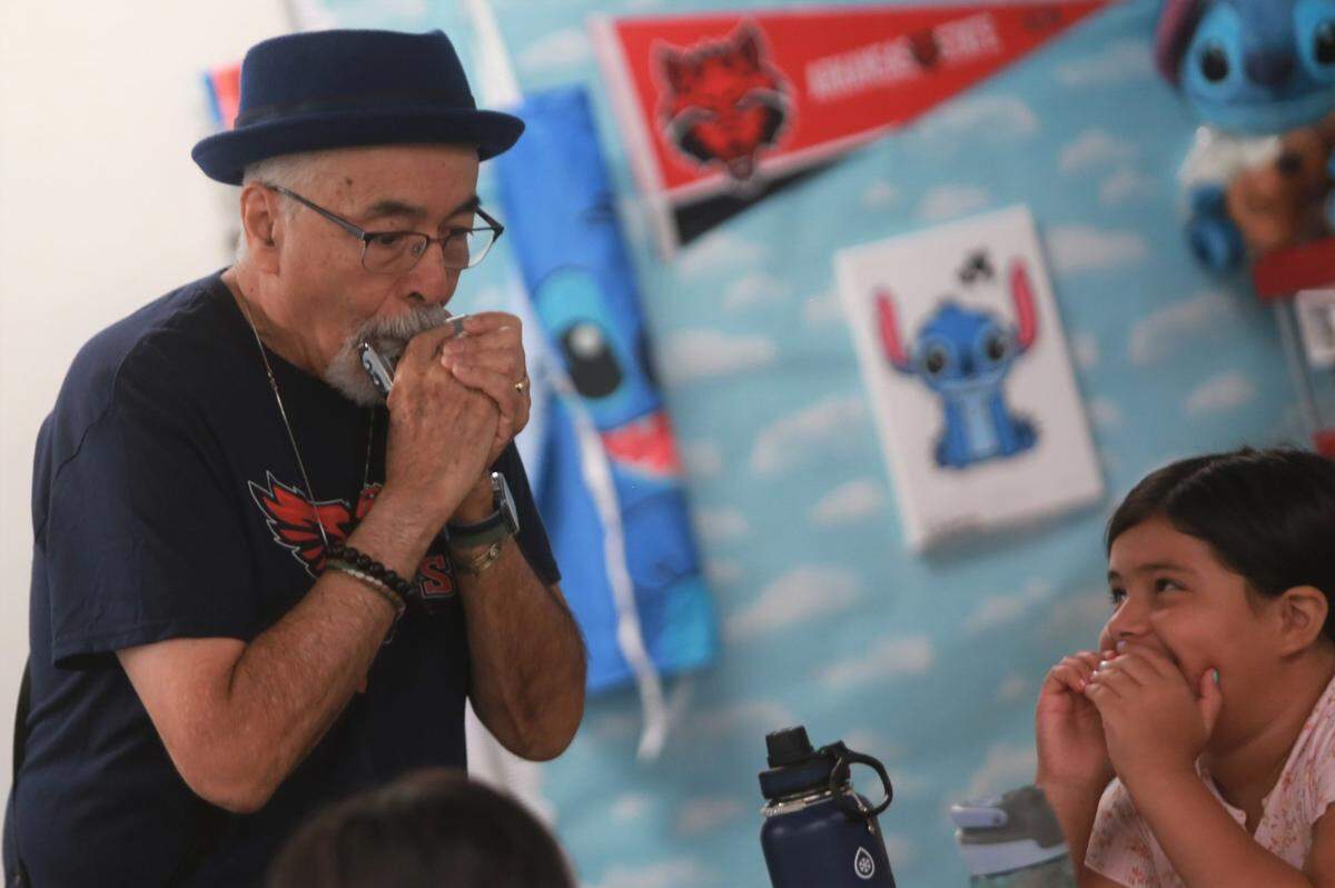 Juan Felipe Herrera visited Myisha Lea’ea’s fourth-grade class on the first day that Juan Felipe Herrera Elementary School opened its doors. Herrera playing the harmonica to students.