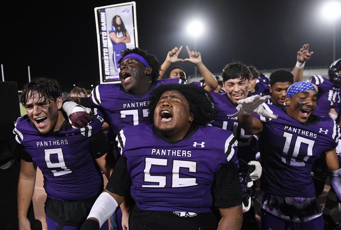 With a portrait of Ernesto Garin in the background, Washington Union celebrates its 33-32 win over Tulare Union Friday, Sept. 3, 2021 in Easton.