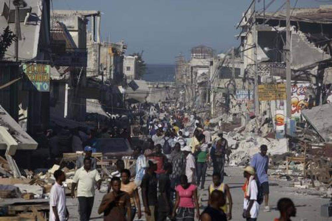 Earthquake survivors walk amidst collapsed buildings and rubble in downtown Port-Au-Prince, Thursday, Jan. 14, 2010. (AP Photo/Julie Jacobson)