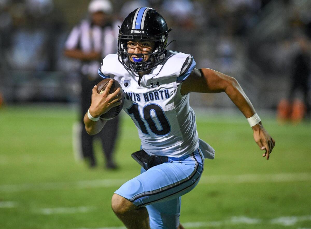 Clovis North quarterback Mario Cosma scrambles out of the pocket on a keeper during their TRAC opener against Clovis East at Lamonica Stadium on Friday, Sept. 29, 2023.