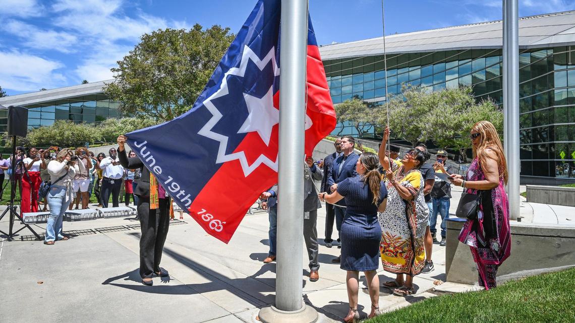 Fresno Juneteenth Festival event director Janice Sumler, in yellow at right, raises the Juneteenth flag over Fresno City Hall for the fist time while surrounded by city leaders and supporters on Monday, June 20, 2022. The flag-raising culminated a series of events celebrating Juneteenth, which commemorates the date enslaved African Americans in Texas were informed of their freedom by a Union general. President Joe Biden signed legislation last year making it a new federal holiday. In describing the holiday, Fresno Deputy Mayor Matthew Grundy said, “It’s about restoration. It’s about a new day.”