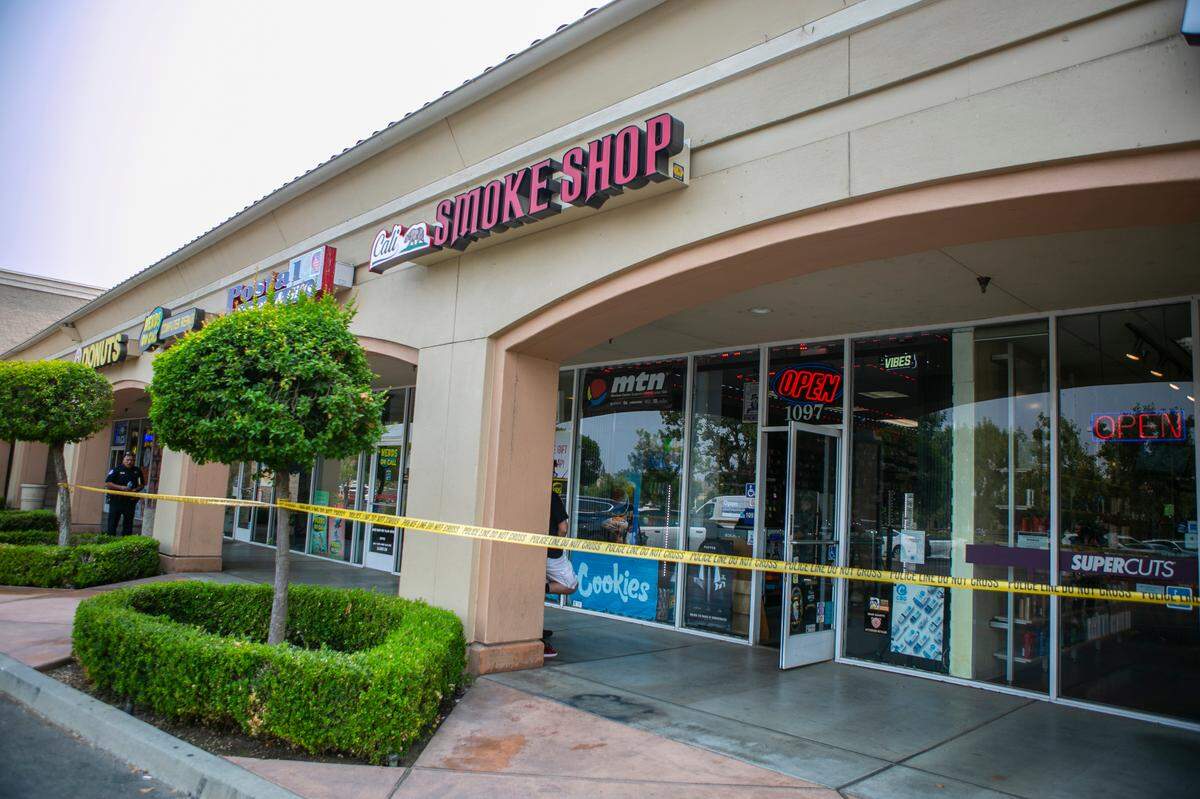 Cali Smoke Shop is cordoned off after it was the scene of a robbery in the northeast Fresno shopping center Monday, Aug. 16, 2021.