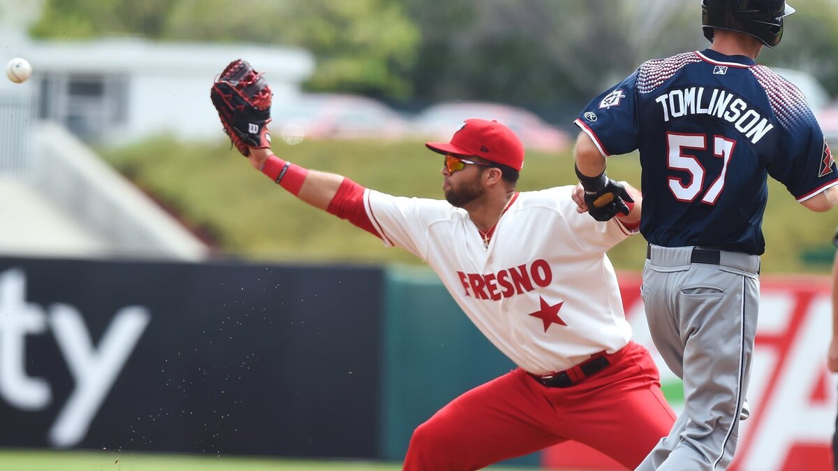 Fresno Grizzlies first baseman Jose Marmolejos stretches for the throw to put Reno Aces baserunner Kelby Tomlinson out, Monday, April 8, 2019 in Fresno.