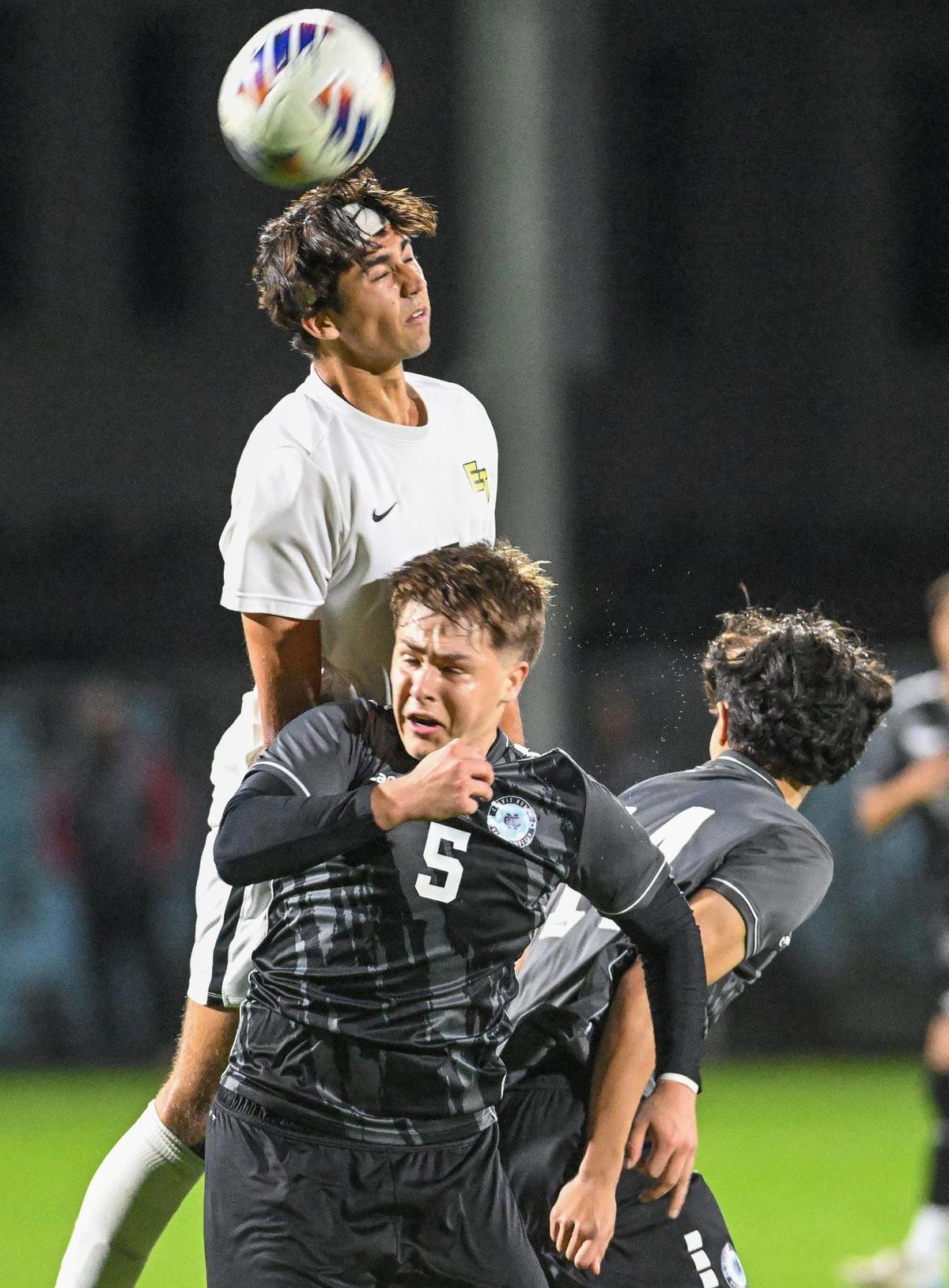 Edison’s Zerin Sheriff, top, battles Clovis North players Brady Downing, left, and Cason Cuaderno in the first half of their Division 1 soccer final at Clovis North on Thursday, Feb. 27, 2025.