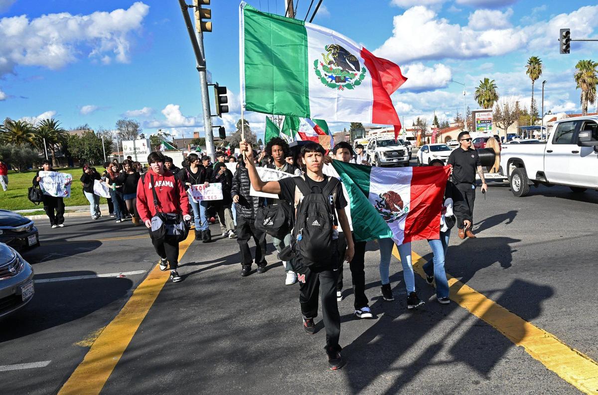 Students from McLane High School cross Dakota Avenue as they march along Cedar Avenue protesting anti-immigration sentiment in the Federal government Friday, Feb. 7, 2025 in Fresno.