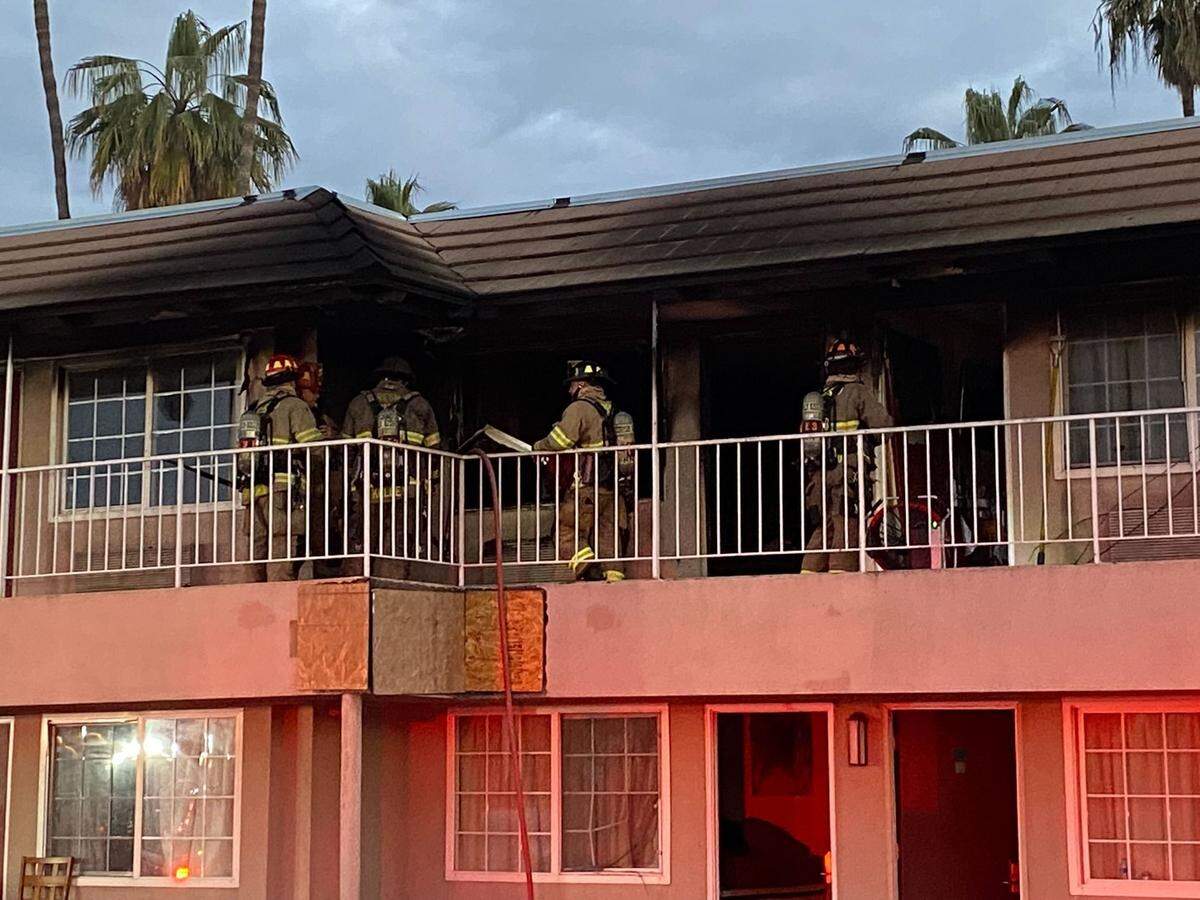 Firefighters check a unit after a blaze at the former Days Inn now used for housing homeless people on Parkway Drive in Fresno, California, on Tuesday, March 14, 2022.