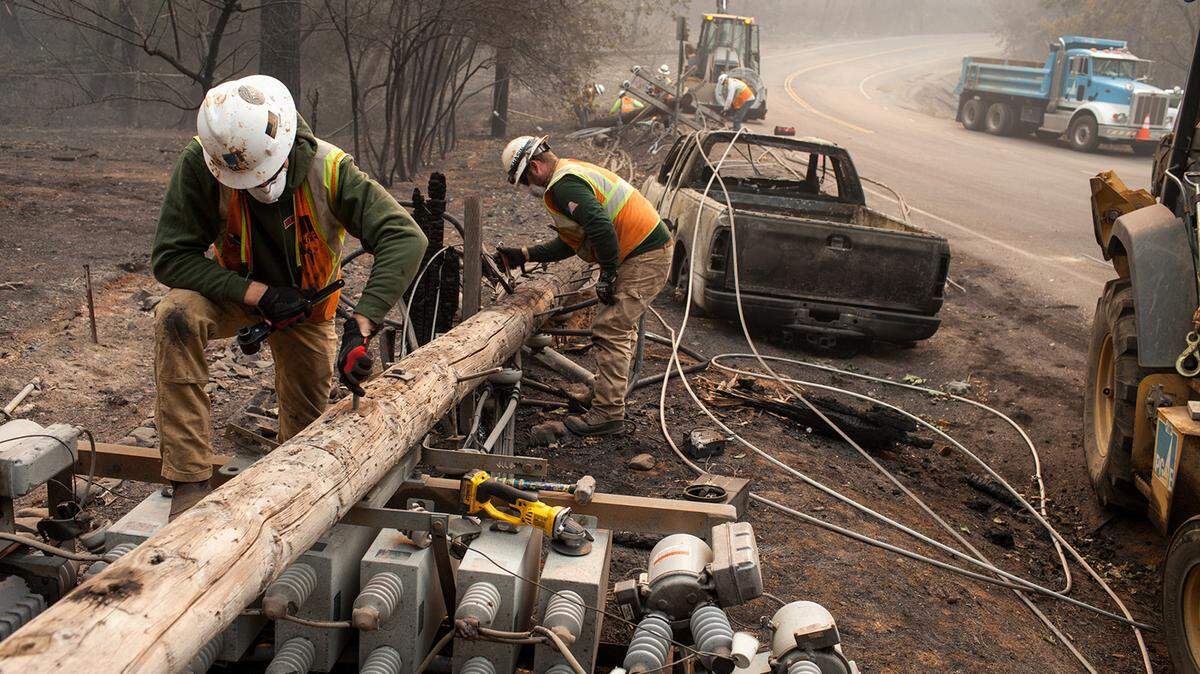 PG&E workers dissemble broken power lines after the Camp Fire ripped through Paradise.