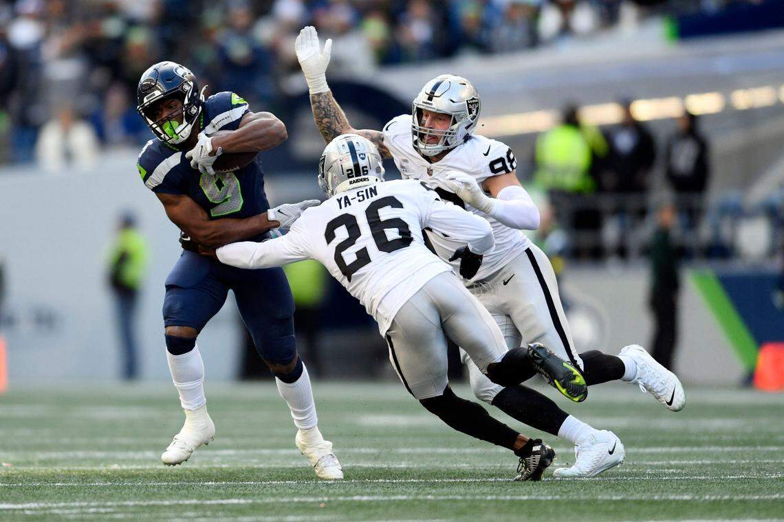 Seattle Seahawks running back Kenneth Walker III runs past Las Vegas Raiders cornerback Rock Ya-Sin and defensive end Maxx Crosby during the first half of an NFL football game Sunday, Nov. 27, 2022, in Seattle.
