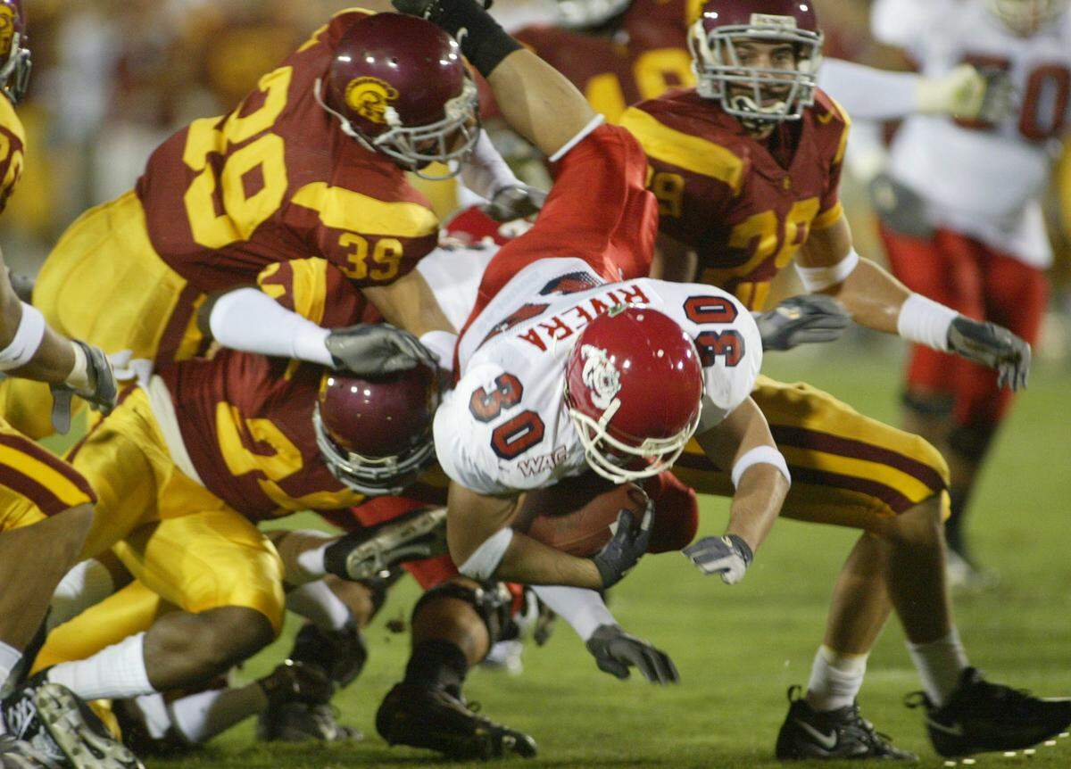Fresno State's Matt Rivera leaps through the USC defense for a first down during the first half.