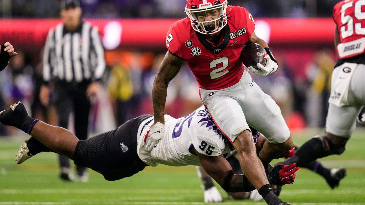 Georgia running back Kendall Milton runs past TCU defensive lineman Terrell Cooper during the first half of the national championship NCAA College Football Playoff game, Monday, Jan. 9, 2023, in Inglewood, Calif.