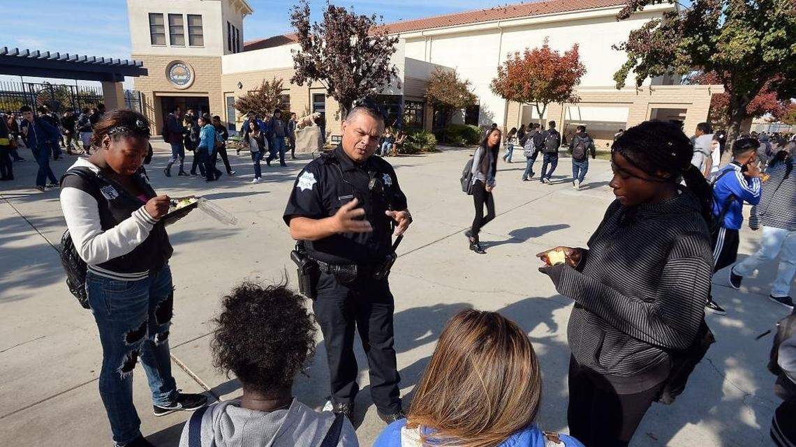 Student Resource Officer Roland Diaz speaks with a group of students during lunch at Sunnyside High School in Fresno.