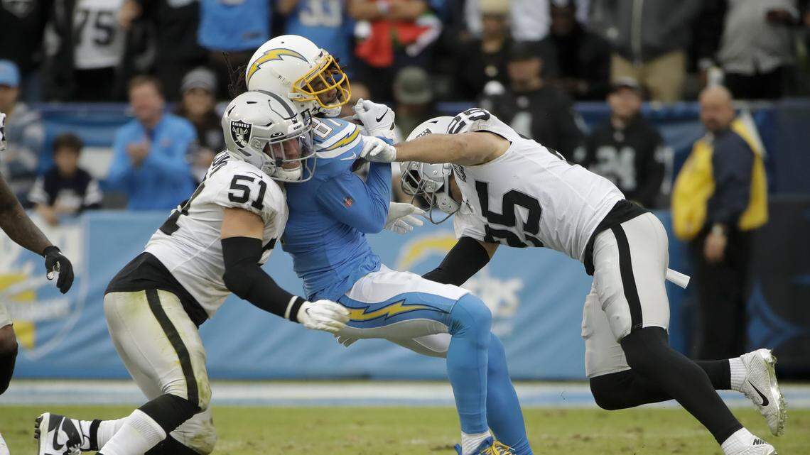 Los Angeles Chargers wide receiver Mike Williams, middle, is tackled by Oakland Raiders inside linebacker Will Compton, left, and free safety Erik Harris during the second half of an NFL football game Sunday, Dec. 22, 2019, in Carson, Calif.