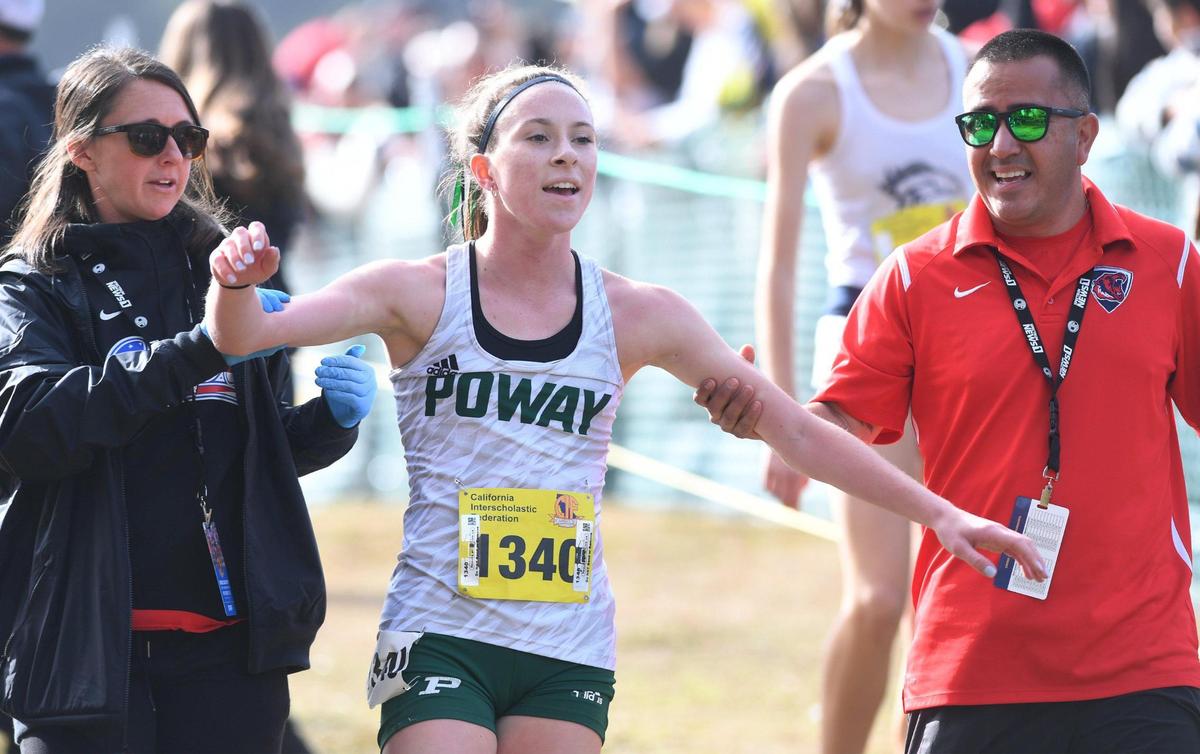 Poway’s Tessa Buswell is supported as she celebrates her first place finish in the CIF Girls D-I State Cross Country Championship, coming form behind to beat favorite Buchanan Saturday, Nov. 26, 2022 in Fresno.