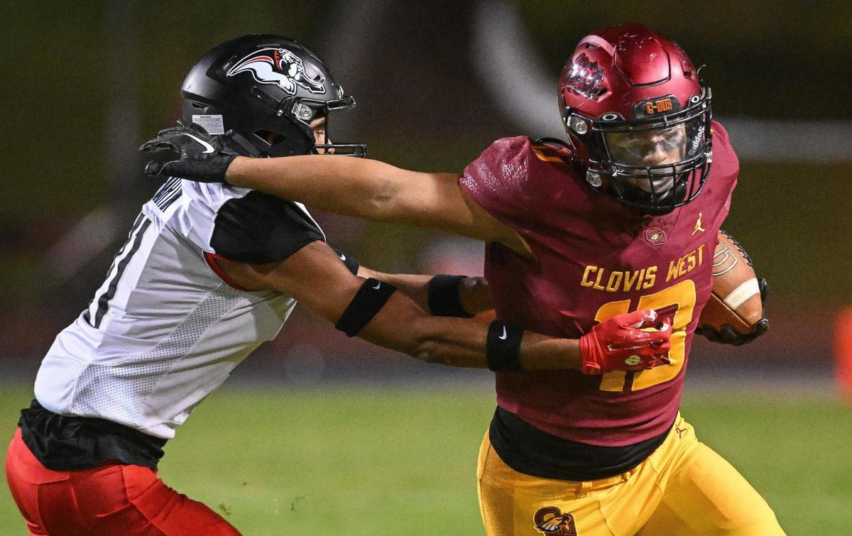Clovis West’s Michael Espinoza, right, spins away from Hanford’s Elijah Felder on a screen pass in their first-round Central Section playoff game at Veterans Memorial Stadium in Clovis on Friday, Nov. 3, 2023.