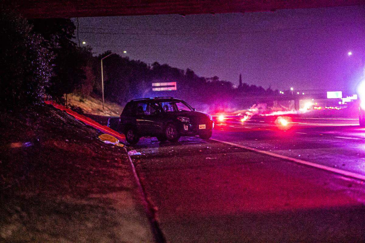 A car sits on the shoulder of Highway 41 near Ashlan Avenue in Fresno at the scene of a fatal hit-and-run collision late Friday night.