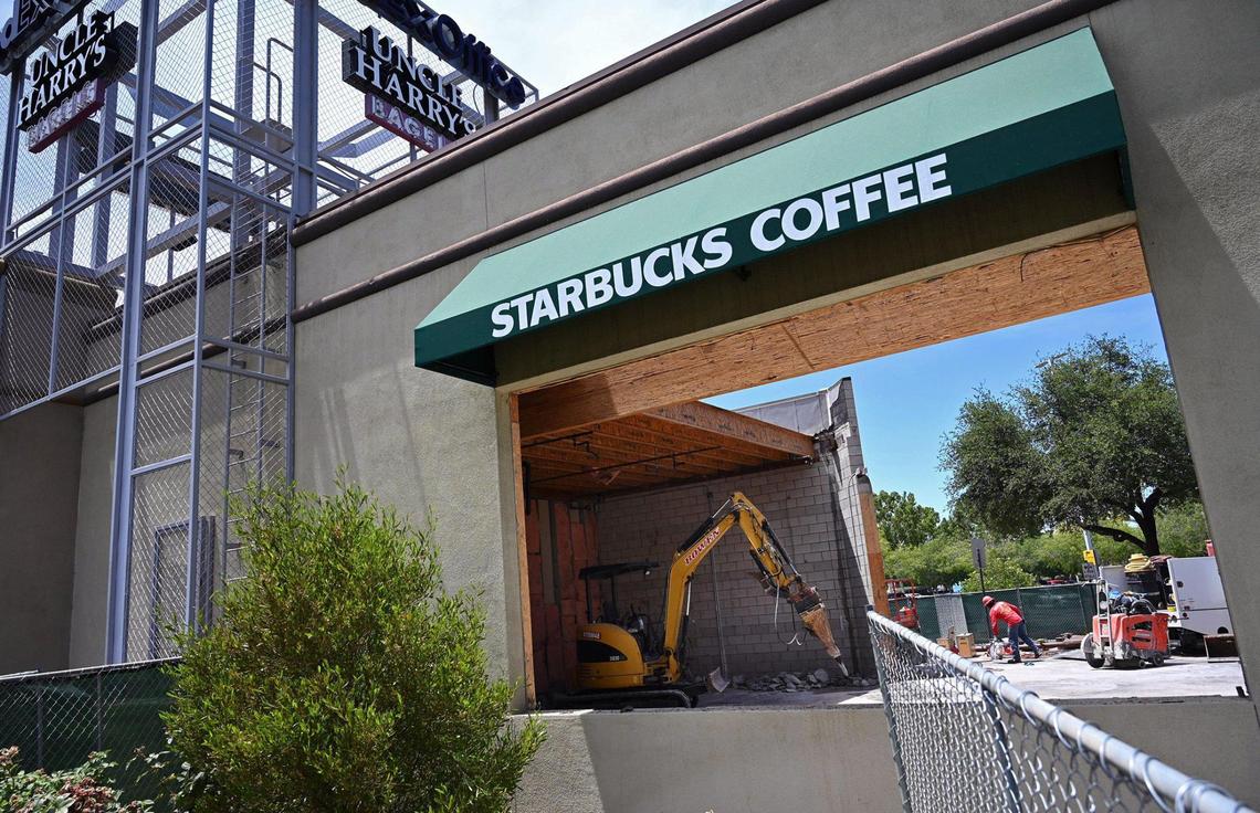 A construction worker is seen through the opening for a drive-thru at River Park’s closed Starbucks site Thursday, June 9, 2022 in Fresno. The location will reopen with new features including the drive-thru.
