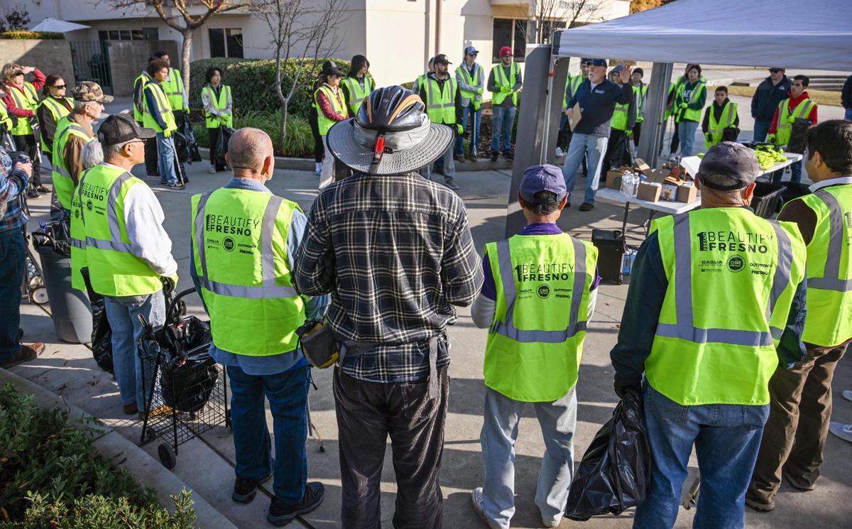 Volunteers gather as Beautify Fresno director Mark Standriff gives direction before the start of a “neighborhood blitz” cleanup event around Nelson Elementary in north Fresno on Saturday, Dec. 9, 2023.