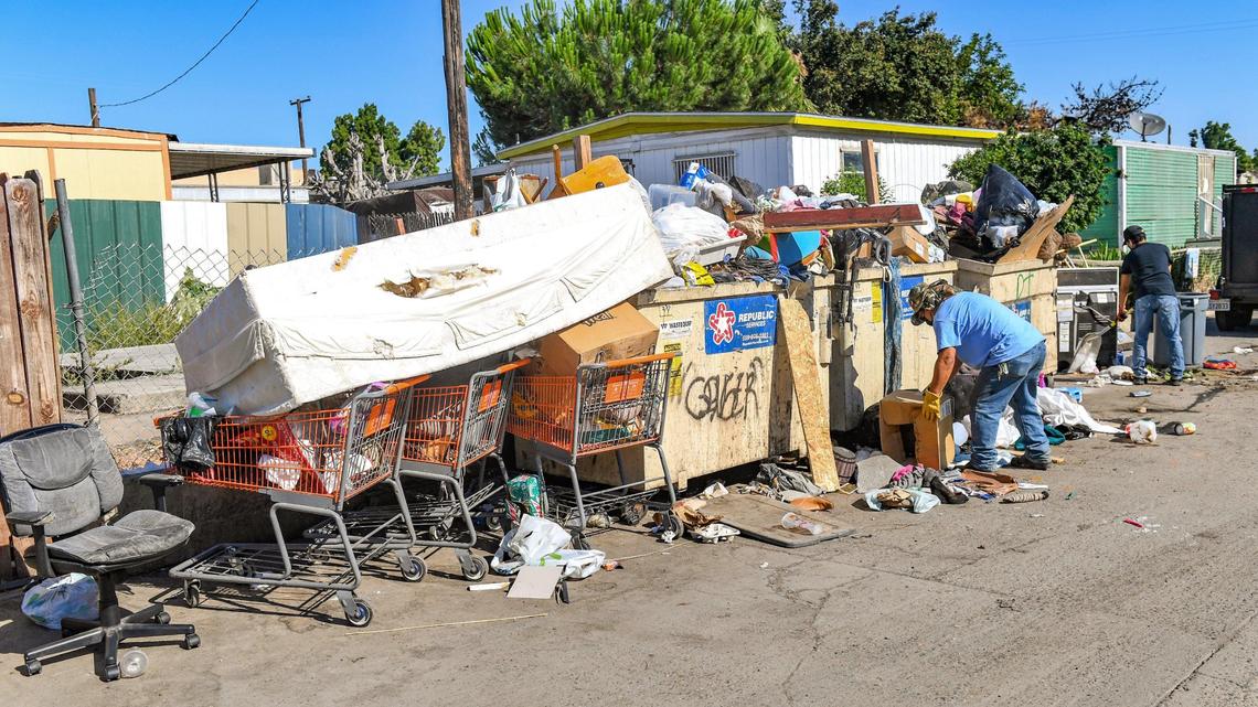Workers remove trash spilling out of dumpsters at Trails End Mobile Home Park in Fresno on Monday, June 28, 2021. The City of Fresno sent a team of code enforcement officers along with investigators from the city police and fire departments to conduct an inspection of the park on Monday.